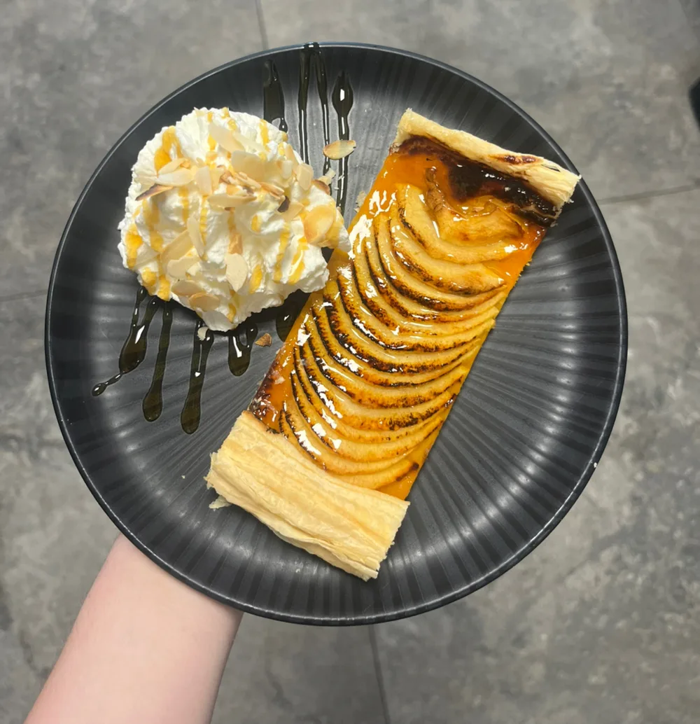 Tarte aux pommes avec crème servie aux Arcades